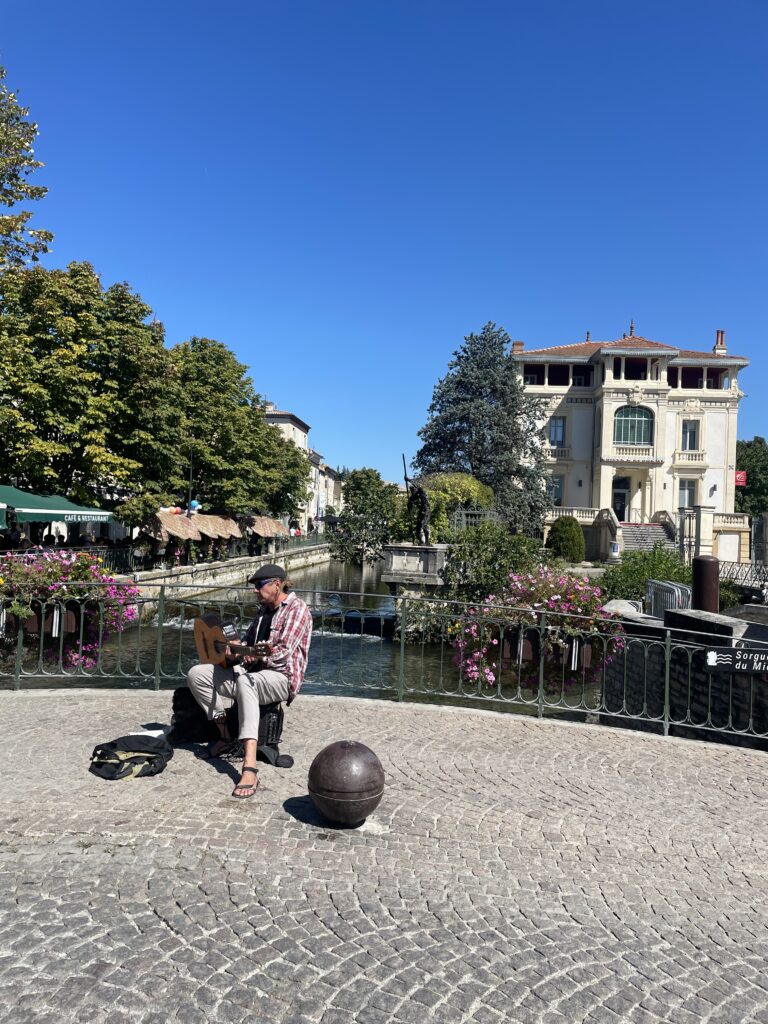 Musicien des rues près de la rivière à l'Isle sur la Sorgue